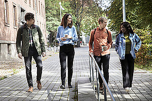 Fyra studenter promenerar i Lund. Foto.